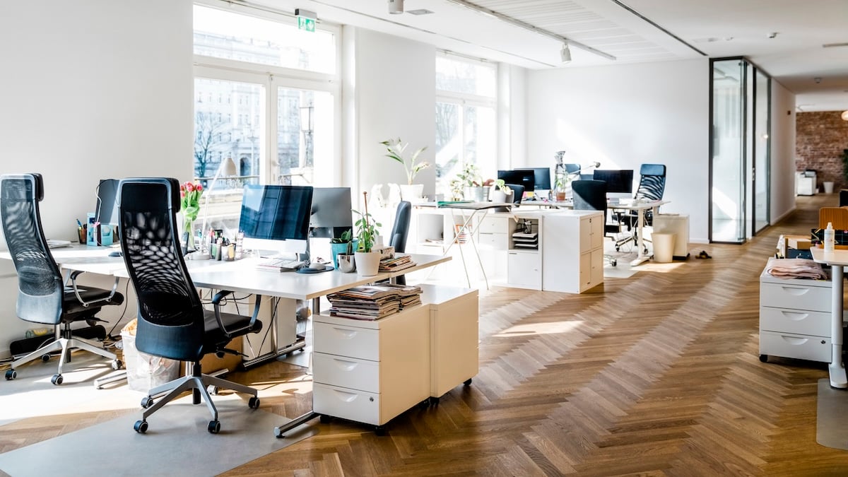 Gen Z Symbolbild: ein leeres modernes Büro mit Holzboden und vielen Schreibtischen mit Computern