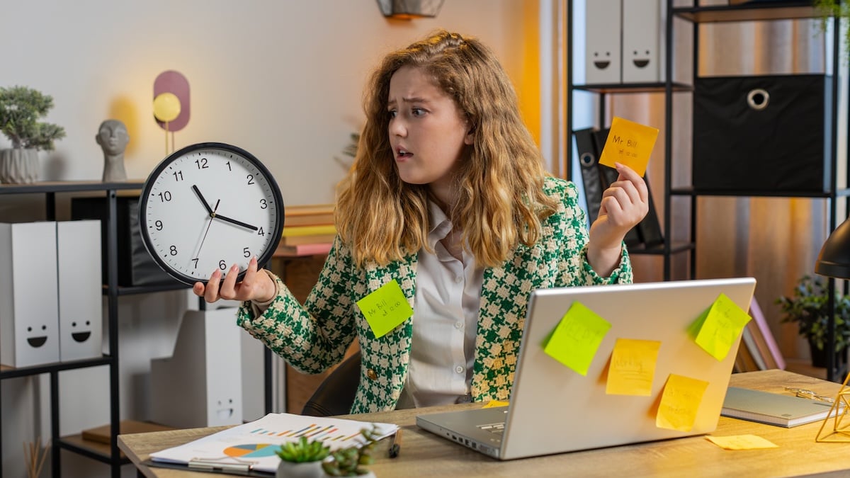 Arbeitszeit Symbolbild:  überarbeitete junge Frau im Büro