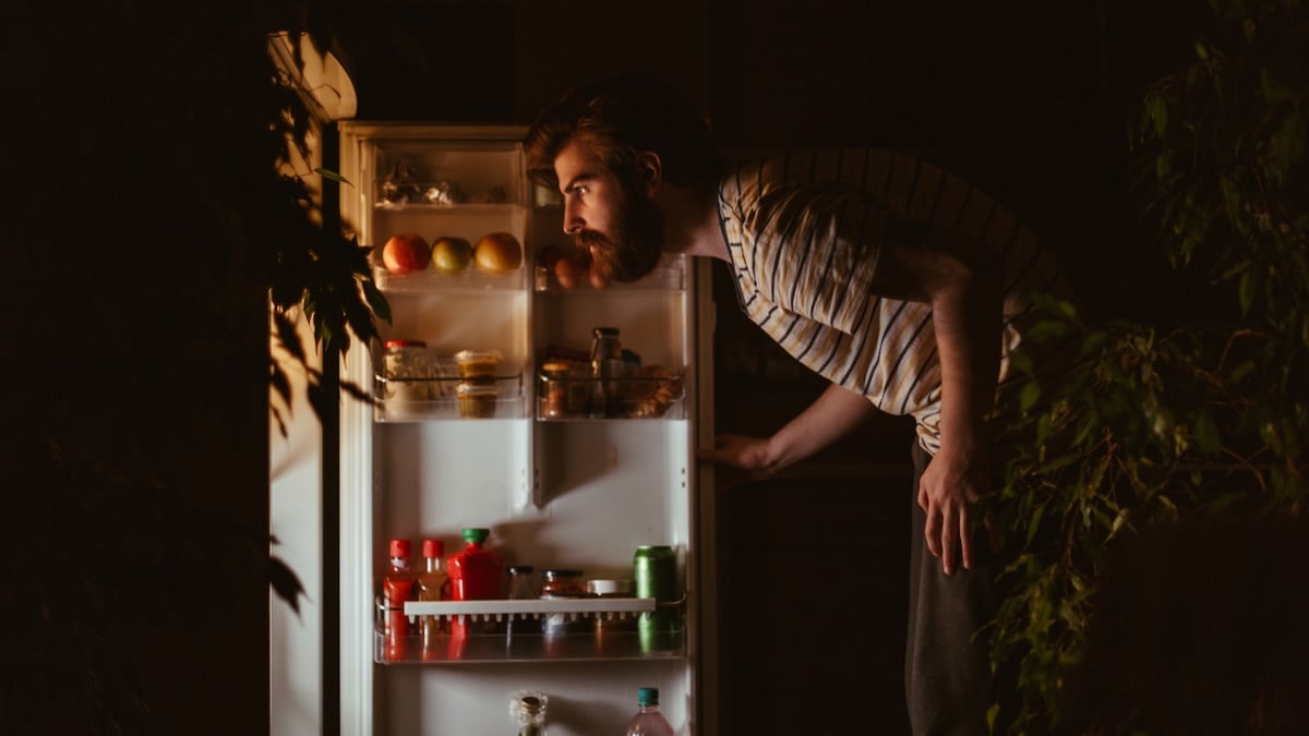 Mann sucht nachts im Kühlschrank nach etwas zu essen