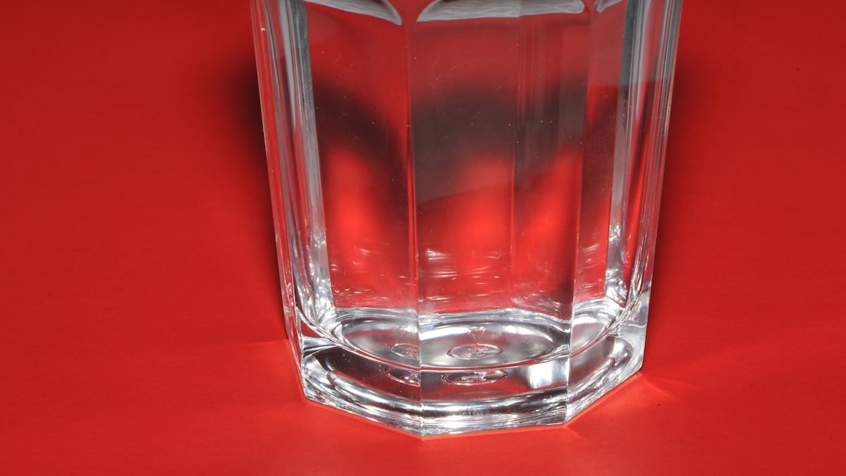 Wasserglas auf rotem Hintergrund