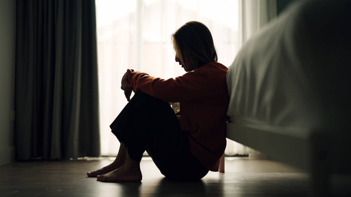 Montagsstress: Silhouette einer Frau, die vor ihrem Bett sitzt