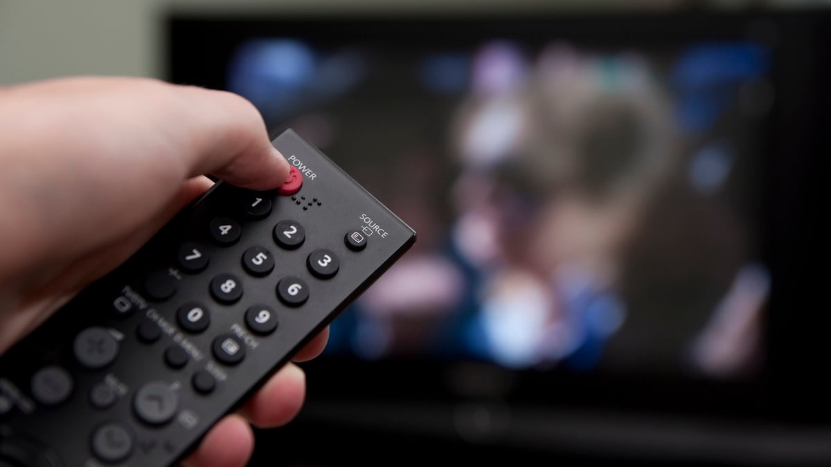 Fernbedienung zeigt auf TV, der gleich ausgeschaltet werden soll
