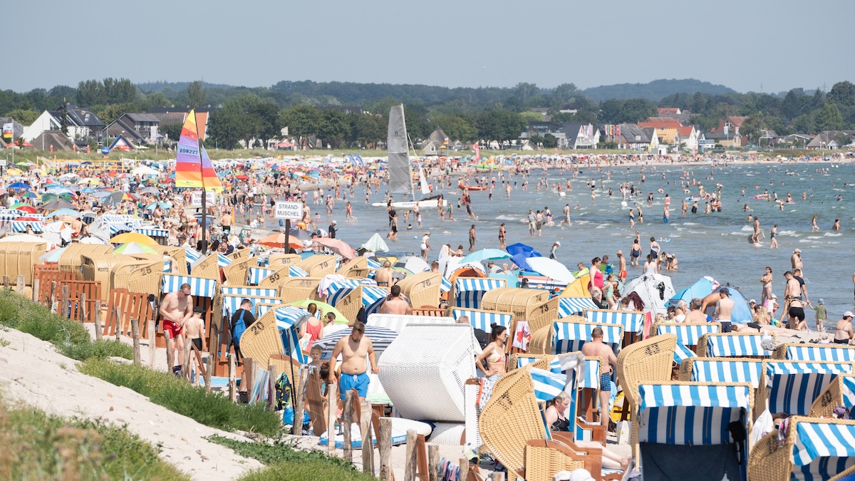 Beach Sprawling: Überfüllter Strand mit vielen Menschen, Sonnenschirmen und Strandzelten