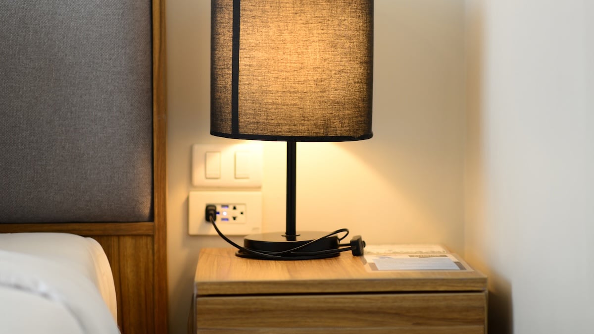Keime Hotel: Nachttisch mit Lampe und Kabeln in einem Hotelzimmer