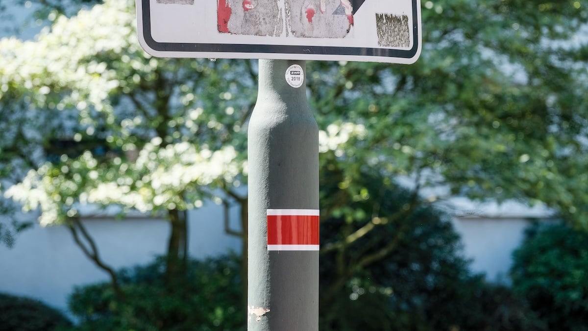 Rot-weißer Laternenring unterhalb eines Schildes angebracht