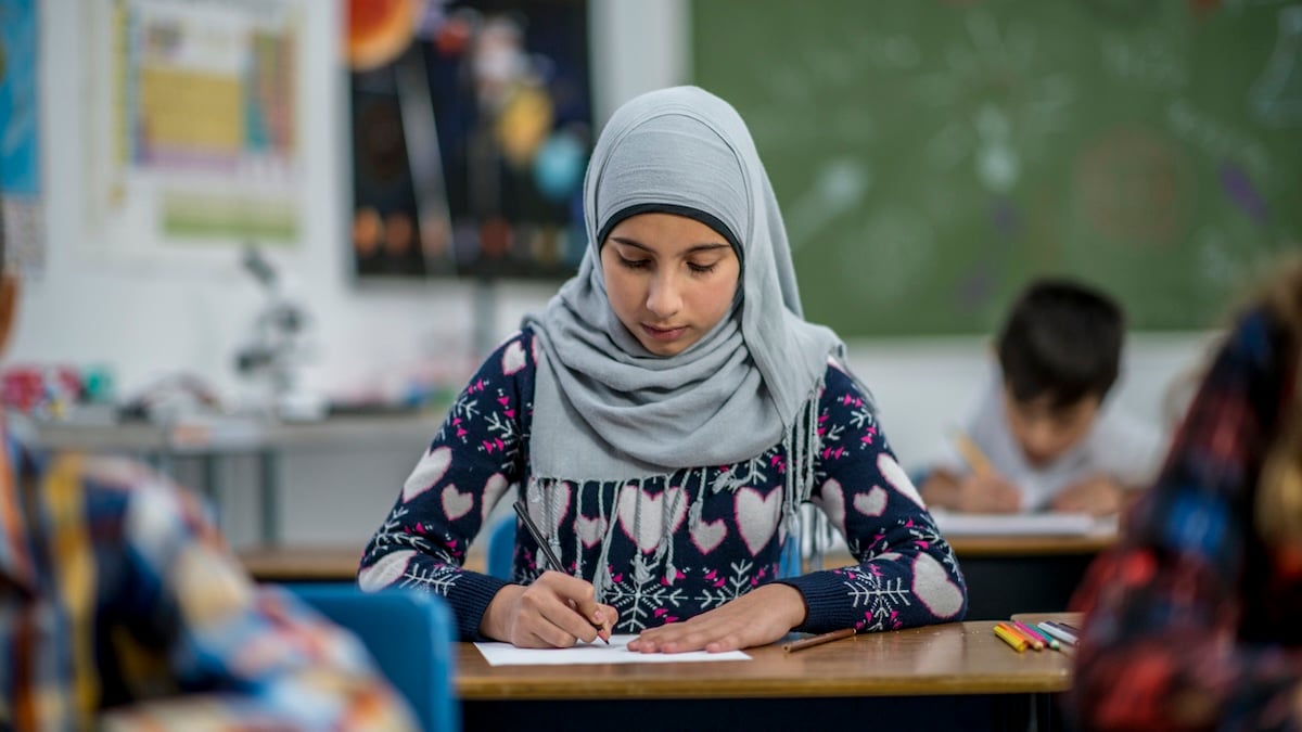 Kopftuchverbot: Junges Mädchen mit Kopftuch sitzt im Schulunterricht