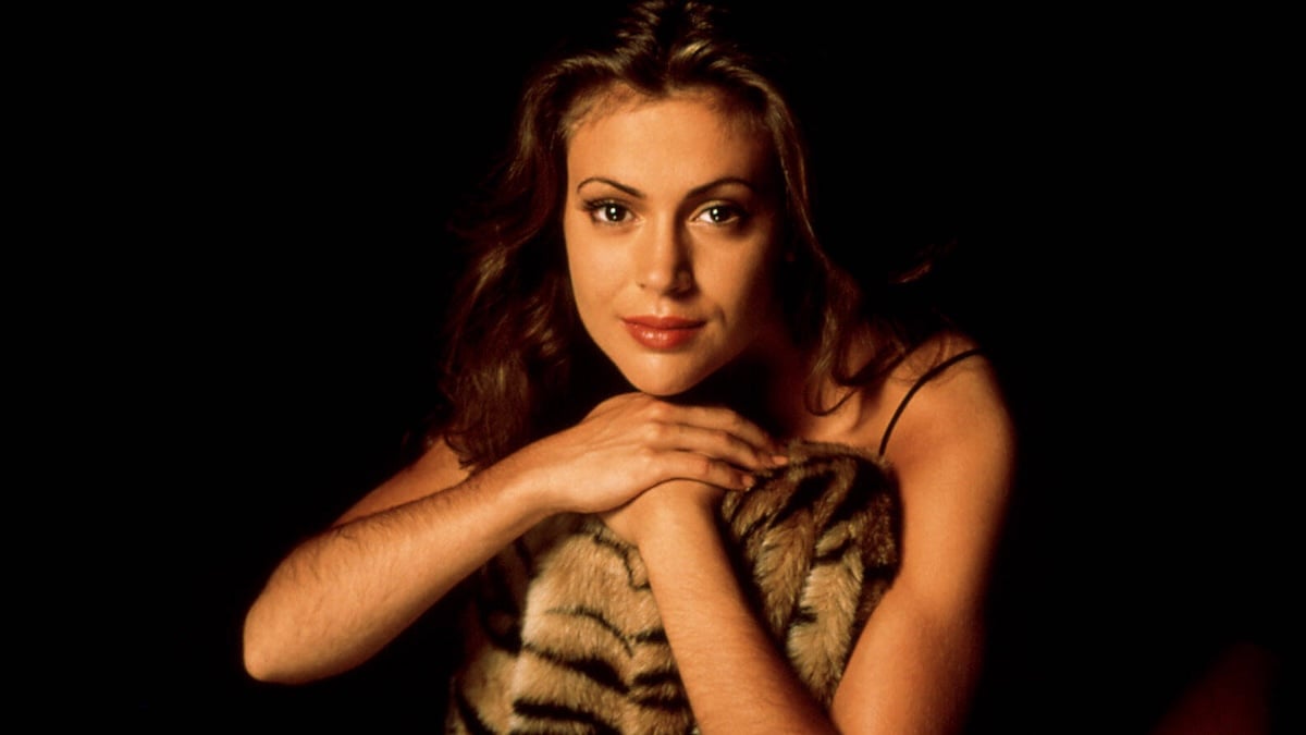 Alyssa Milano 1990 vor dunklem Hintergrund