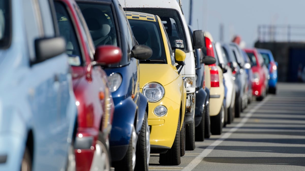 Autos in vielen verschiedenen Autofarben fahren hintereinander auf einer Straße