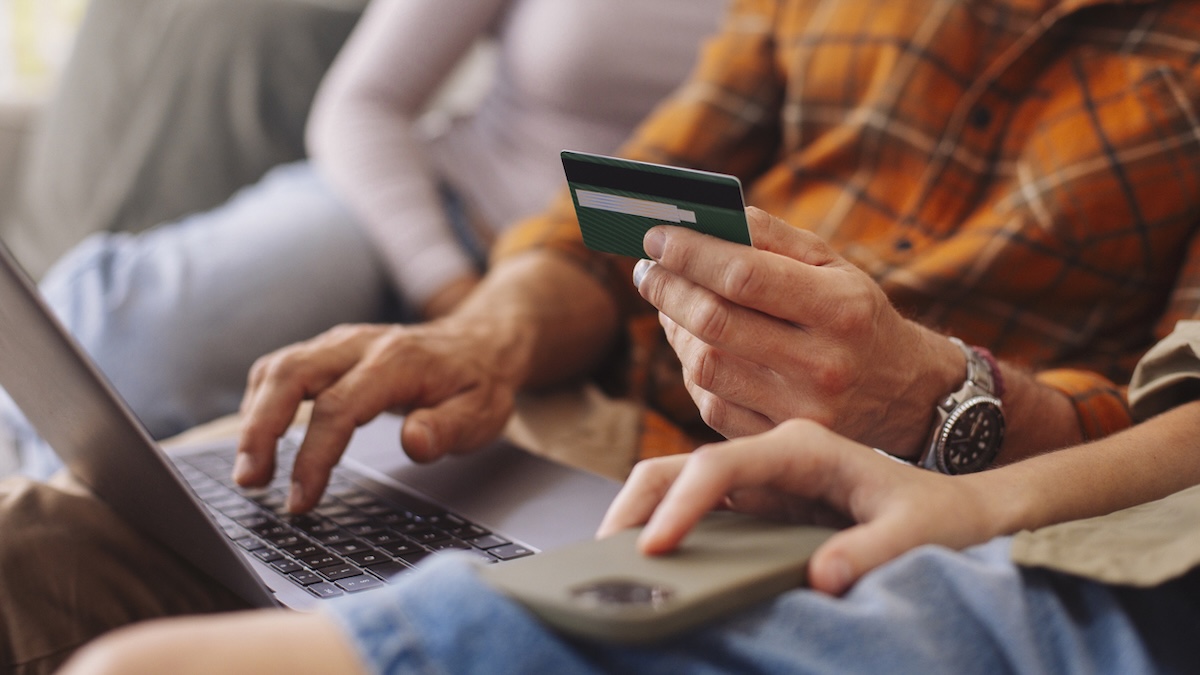 Vorsicht zum Black Friday: Verbraucher sollten sich vor zahlreichen Fakeshops in Acht nehmen 5 Warnung vor Fakeshops: Familie sitzt mit Kreditkarte vor einem Laptop