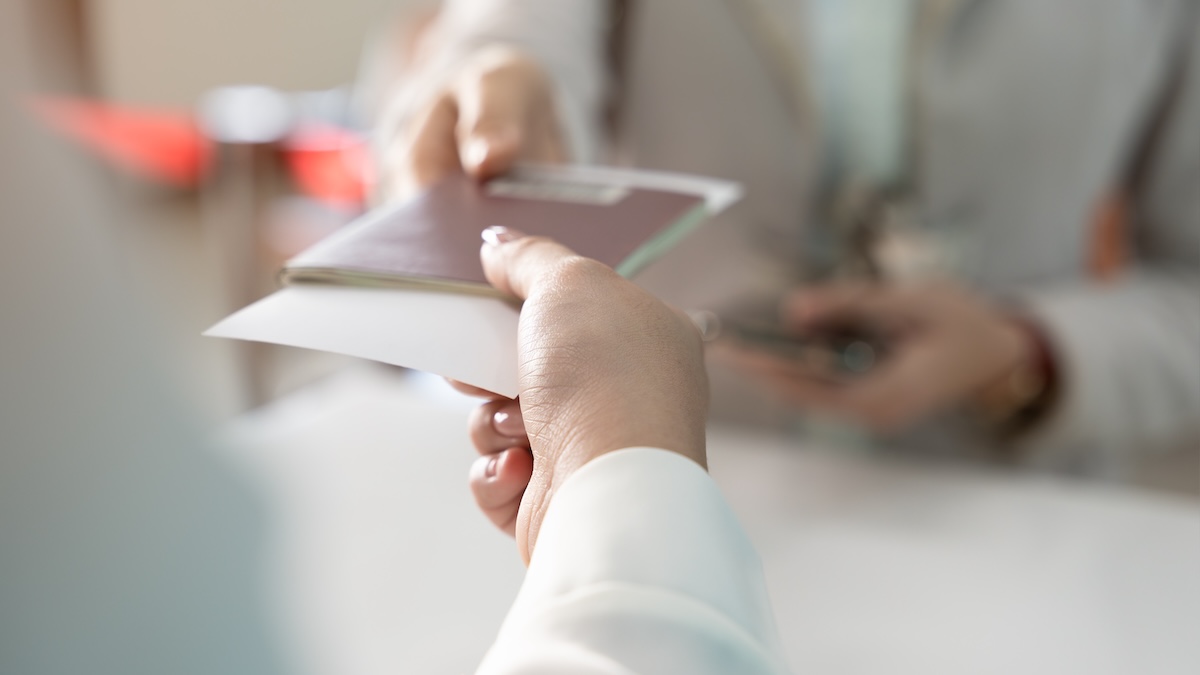 Post-its im Reisepass: Wie der Trick jede Menge Ärger ersparen kann 5 Frau nimmt am Flughafen ihren Reisepass entgegen