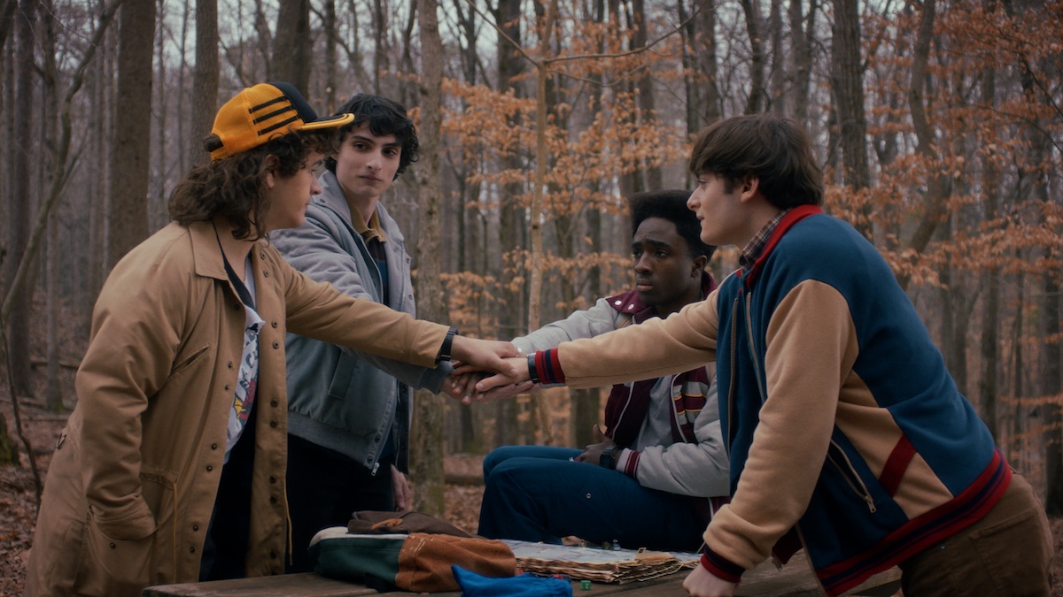 Verlorene erste Episode von „Stranger Things“: Hit-Serie hätte fast ganz anders ausgesehen 20 Szene aus „Stranger Things“, in der sich vier Jugendliche in der Mitte die Hand reichen