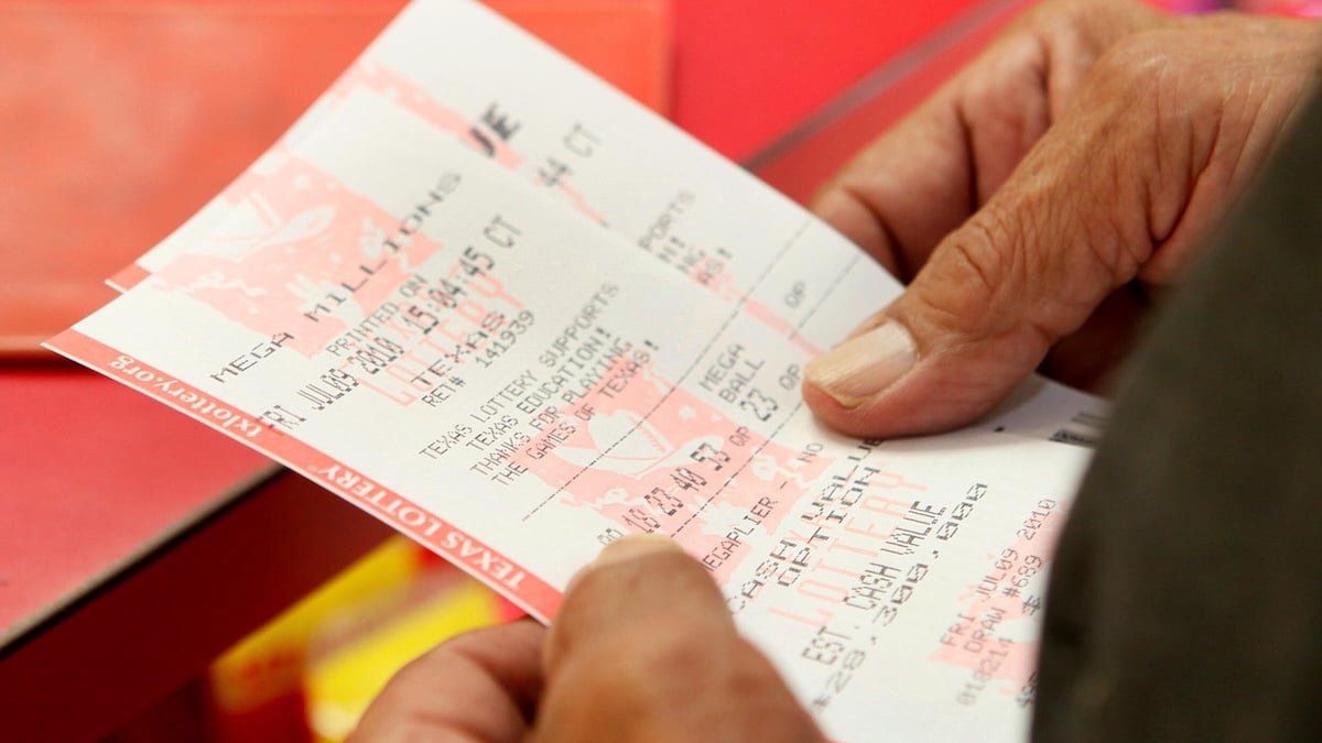 Jemand hält zwei Lotto-Scheine in der Hand, die aus der Filiale in Texas stammen, in der Joan Ginther zweimal ein Gewinnerlos kaufte