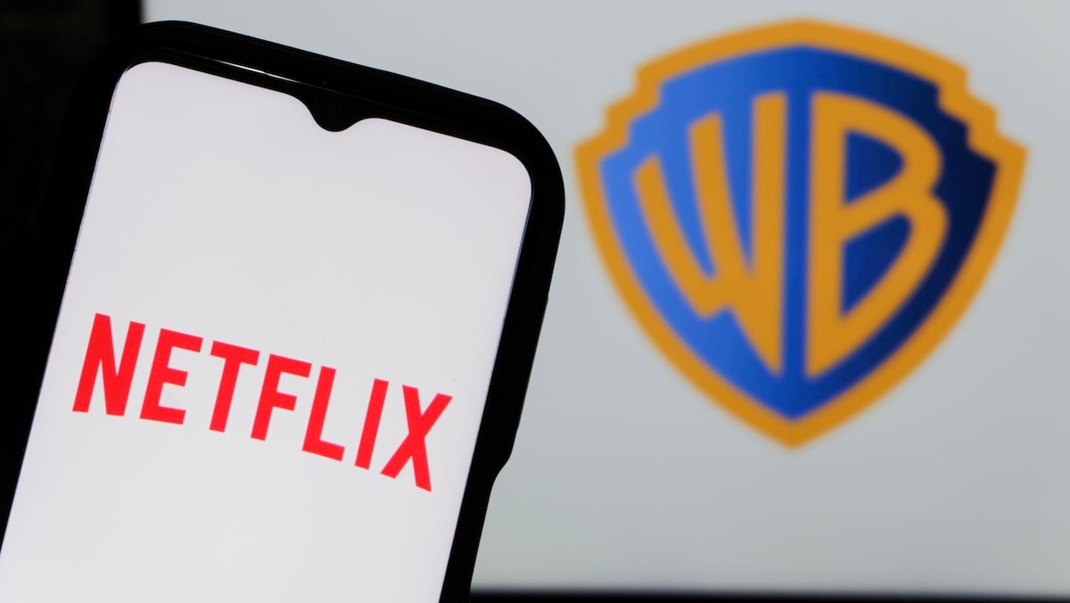Netflix-Logo auf einem Smartphone neben dem Logo von Warner Bros.