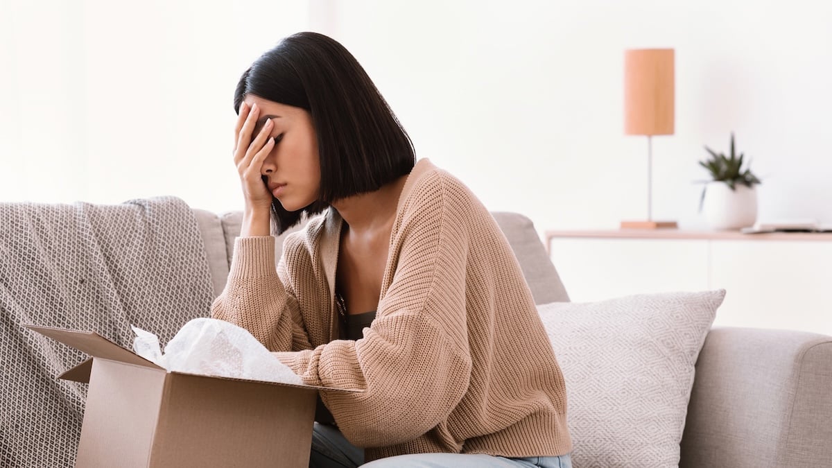 Polizei warnt: Deshalb sollte man keine Pakete für Nachbarn annehmen 8 Pakete für Nachbarn annehmen: Frau stützt schockiert das Gesicht in die Hand, nachdem sie ein Paket geöffnet hat