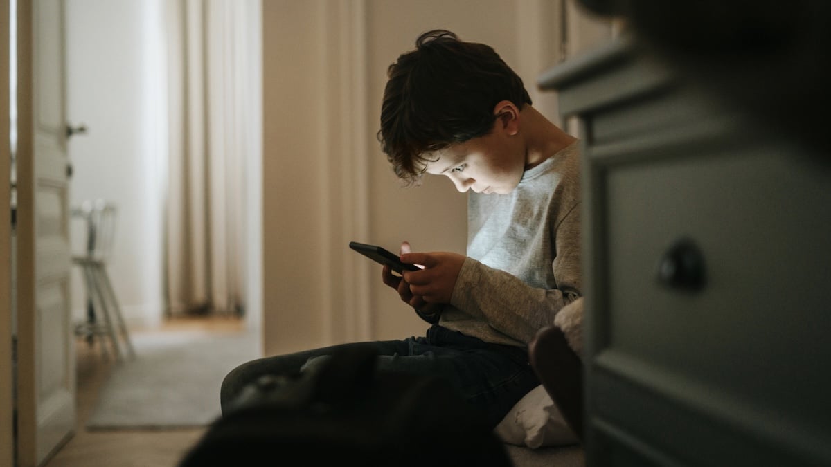 „Taschengeld-Treffen“: LKA warnt Eltern vor wachsendem Phänomen 13 LKA warnt vor Taschengeld-Treffen: Junge schaut vornübergebeugt auf seine Smartphone