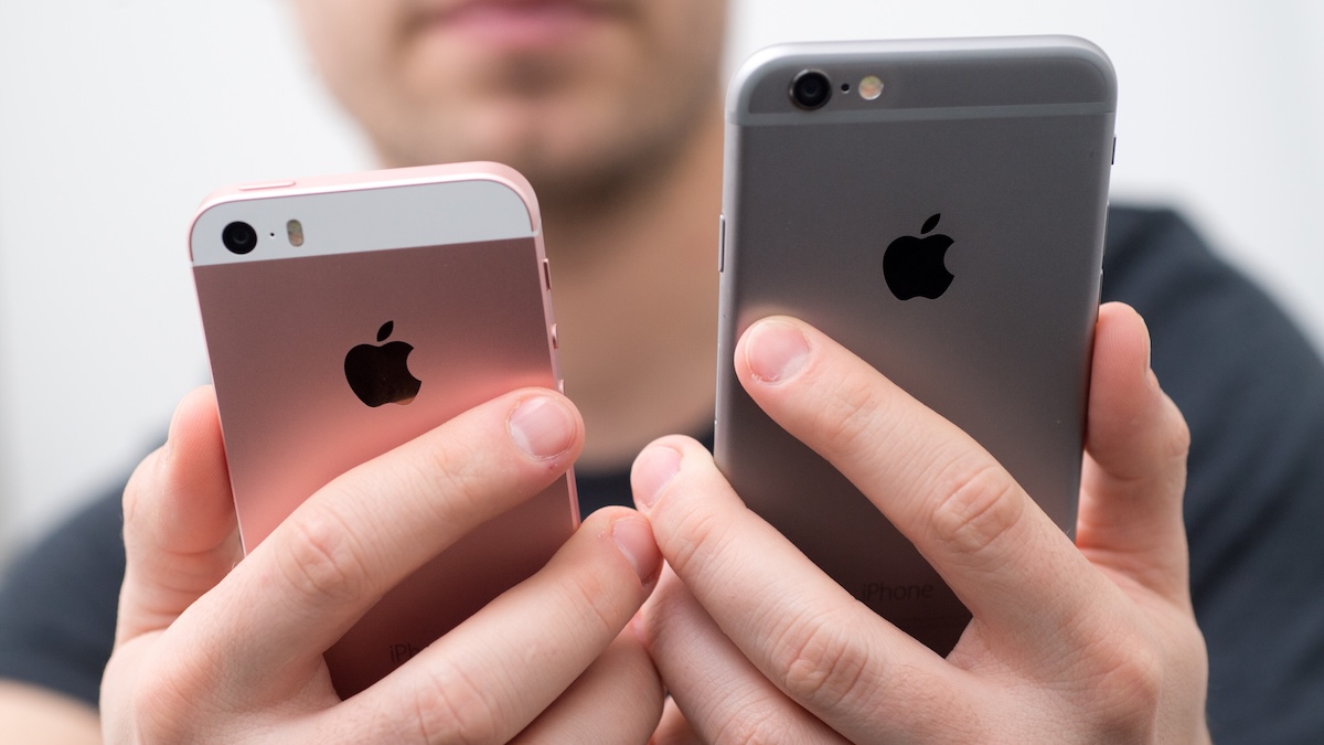 Jemand hält ein iPhone SE (1. Generation) und ein iPhone 6 zum Vergleich nebeneinander